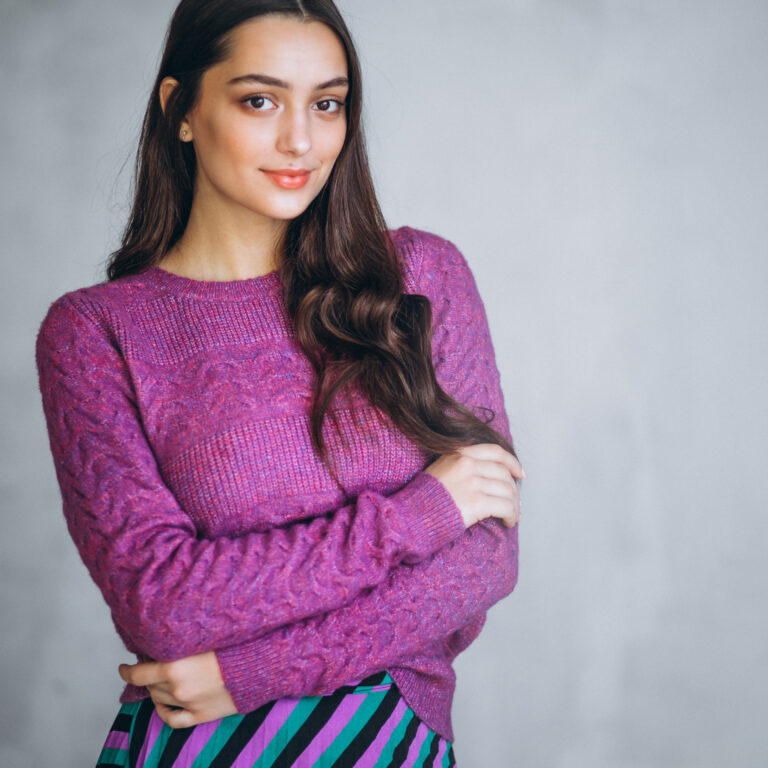 Beautiful woman in a purple sweater and skirt in studio
