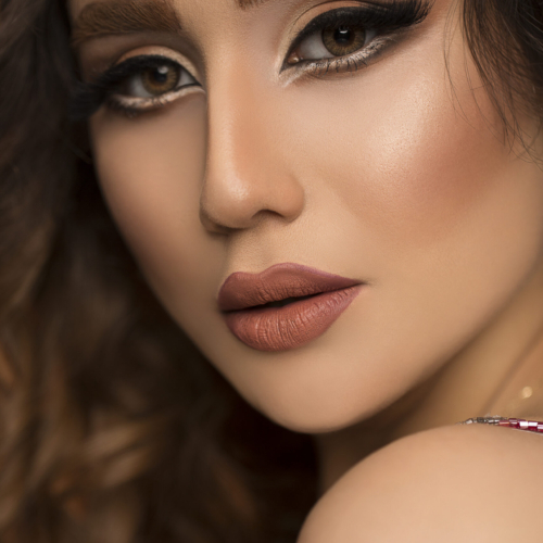Model with bronze makeup, fair haired and long eyelashes